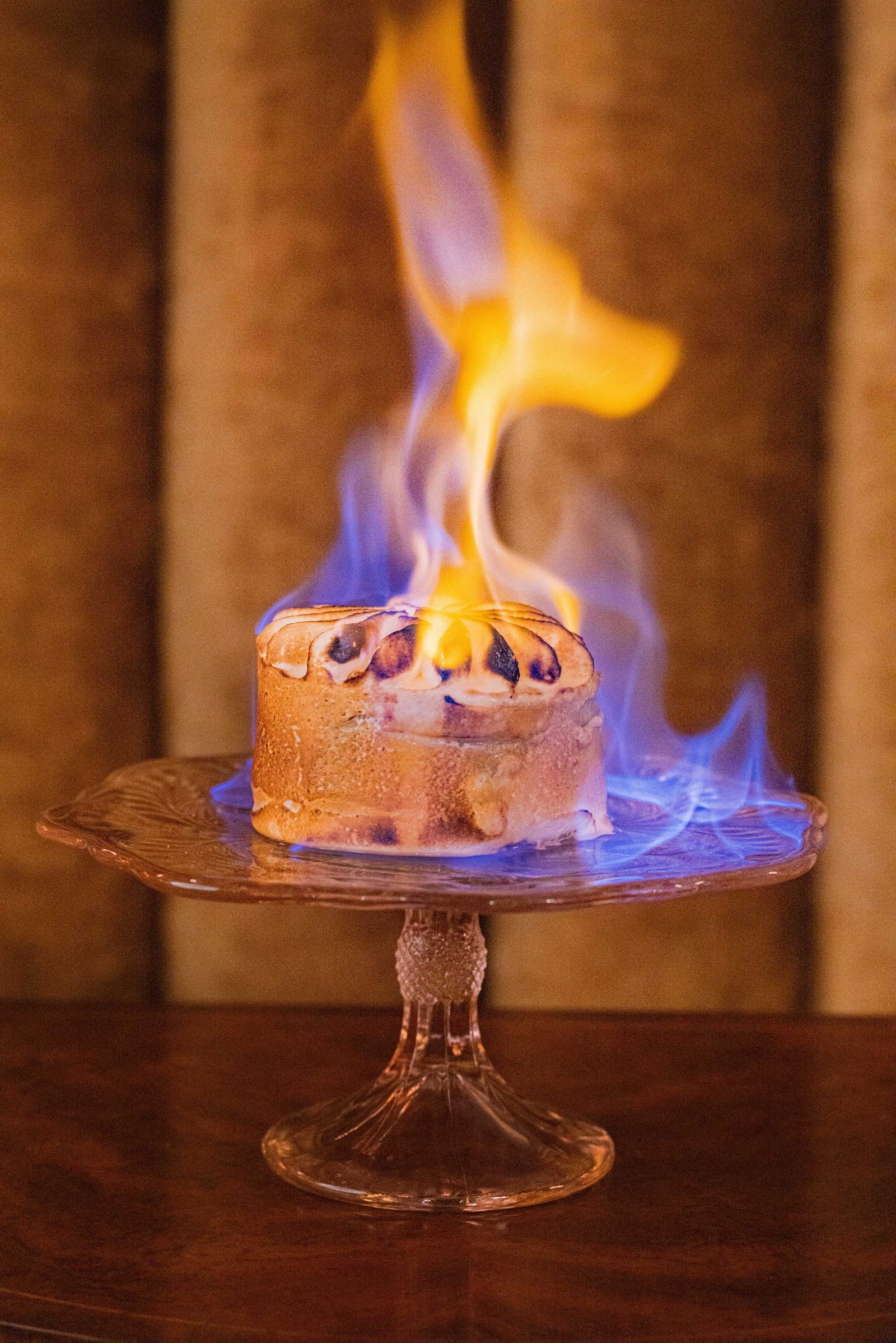 Flaming dessert on a decorative cake stand at Delilah Dallas