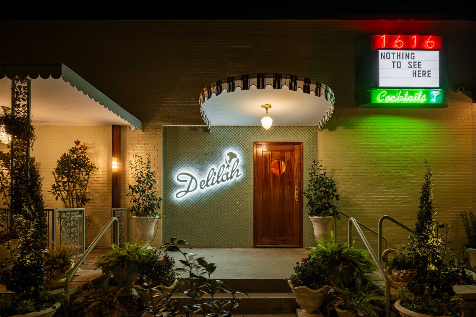 Entrance of Delilah Dallas with decorative sign and vibrant lighting